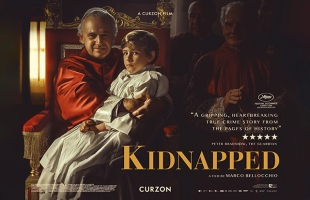 Poster for Kidnapped, a young boy in white is being held on the lap of a Catholic Cardinal, dressed in red, who sits on an elaborate chair.