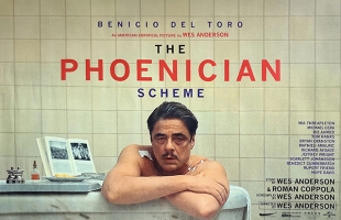 Poster for The Phoenician Scheme. Benicio Del Toro leans over the side of a bath with a black eye, cut lip, and a bandage on his right shoulder.