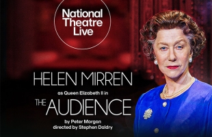 Helen Mirren dressed as Queen Elizabeth II with a curly wig, blue top and pearl accessories looks at the camera in front of a red backdrop