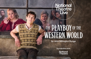 Éanna Hardwicke sits wearing a yellow and brown knitted vest, white t shirt and brown trousers. Behind him through a window, Nicola Coughlan wearing a pink dress and Siobhán McSweeney in a black dress stare at him.