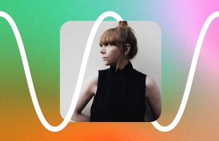 Portrait of Poppy Ackroyd, a woman with auburn hair in a high bun and fringe, wearing a sleeveless black top, looking to the side against a soft gradient background with a white waveform graphic.