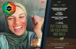 Poster for 'Put Your Soul on Your Hand and Walk' - a young woman wearing a hijab smiles with her fist raised, as she speaks to someone on a video call