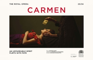 A poster image for Carmen, with the title in large letters above a woman lying down in profile, with an shadowy figure holding a tarot card directly above her face.