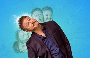 Risgeard Cooper in a dark purple suit tilts his head playfully against a bright blue background, with multiple faded expressions of his face layered behind him.