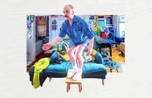 A surreal collage-style scene shows a person with a disproportionately large upper body composited onto a living room setting. The person is balancing with bent knees on a small wooden stool placed on a teal sofa. The person wears a blue patterned shirt, white socks, and no visible trousers, creating an intentionally exaggerated, humorous contrast in scale and proportion.
