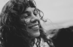 Black and white image of Susan O'Neill smiling, with wind swept hair