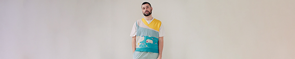 A man wearing a jumper with an illustration of Sandycove's Forty Foot bathing place on it.