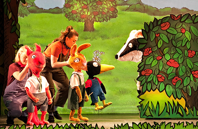Production shot from Tales From Acorn Wood. A rabbit, and bird are making there way towards a badger who is popping out of a hedge.