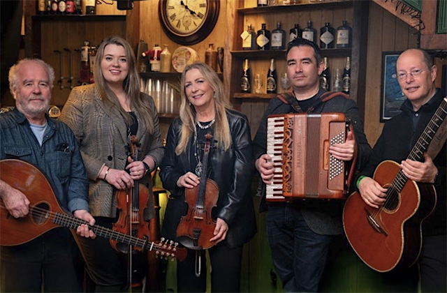 The band members of Altan, posing in a traditional pub with their instruments