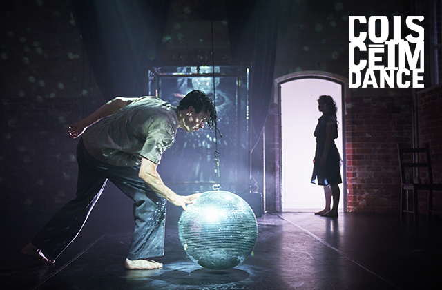 A barefoot male dancer looks down onto a shimmering disco-ball in the foreground, while a silhouetted female dancer stands in a doorway in the background