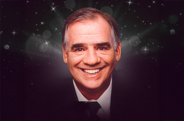 A smiling Joe Dolan surrounded by a dark sparkly back drop