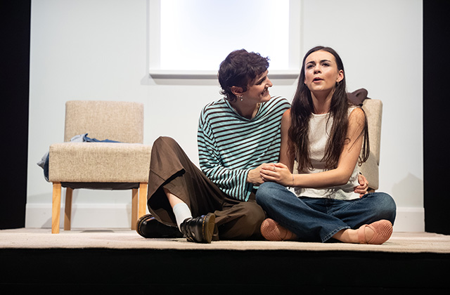 Production images from For Dolores. Mo & Réaltín are sitting together hugging and smiling.