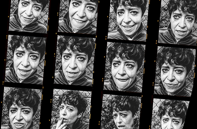 Black-and-white contact sheet featuring twelve close-up portraits of a person with varied facial expressions, arranged in a film-strip style against a chain-link fence background