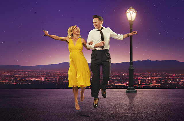 Liza Pullman, dressed in a yellow dress, and Joe Stillgoe, in a suit, arm in arm, dancing by a streetlight