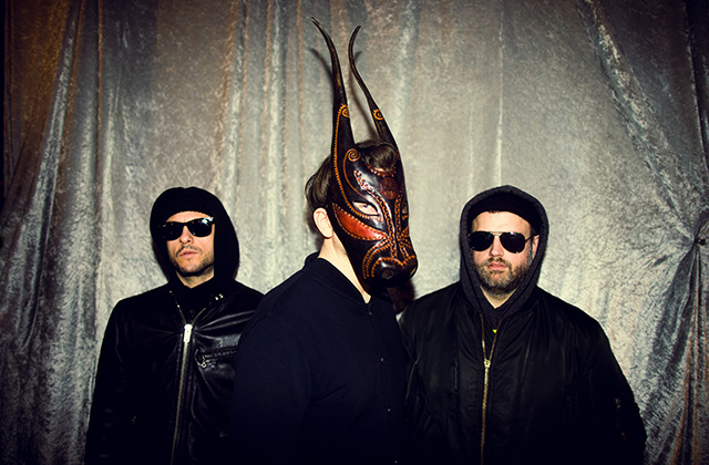 Lambert is pictured standing, with his signature mask, he stares off to the right side. Members of his trio Felix Weigt and Luca Marini stand behind him