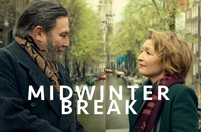 A film poster showing Ciarán Hinds and Lesley Manville standing face to face on a canal-side street, likely in a European city. Hinds has greying hair and a beard, wearing a dark coat and patterned scarf, while Manville has short blonde hair and wears a green coat with a burgundy scarf. They look at each other with calm, reflective expressions. The background features a tree-lined canal, buildings, and soft daylight. Across the centre, large white text reads “MIDWINTER BREAK.”