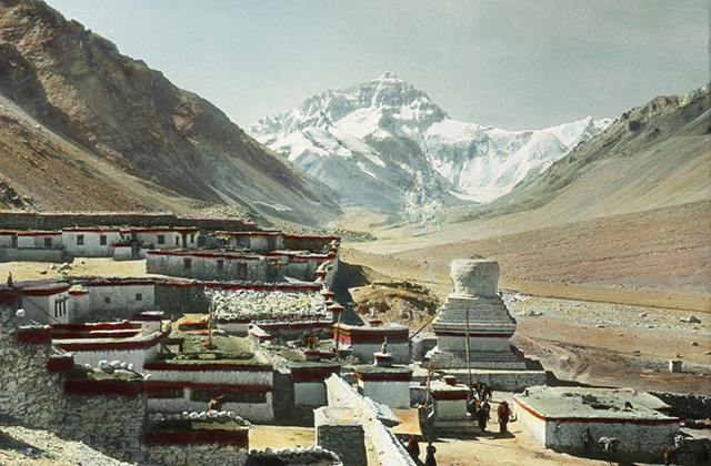 A historical photograph of Tashi Lhunpo Monastery, a complex of buildings nestled in the shadow of the Himalayas.