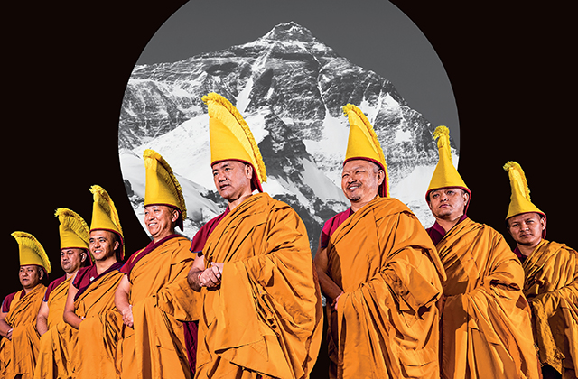 The Tashi Lhunpo monks in ceremonial orange robes and tall yellow hats, against a black-and-white photo of a giant mountain