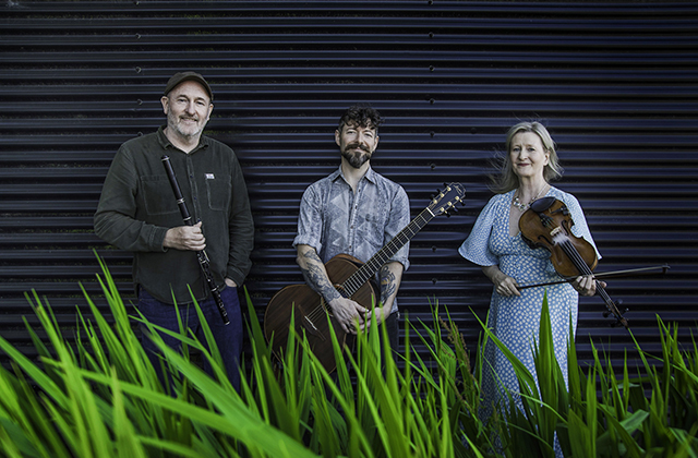 Mike McGoldrick, Niall McCabe and Nollaig Casey standing with their instruments
