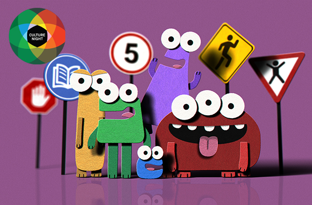Image from 'Sign Up' - a collection of felt made creatures, all different colours, and differing number of eyes stand in a group with road safety signs around them