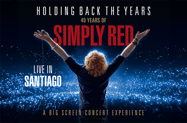 Mick Hucknall, with his back to the camera, stands with his arms raised with a huge crowd of people in front of him