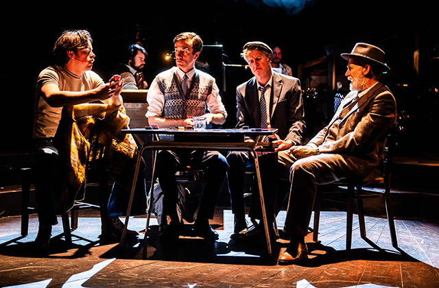 Cast members from The House Must Win are sitting around a table playing cards.